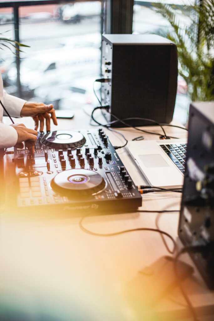 A person working on a DJ controller and a laptop image