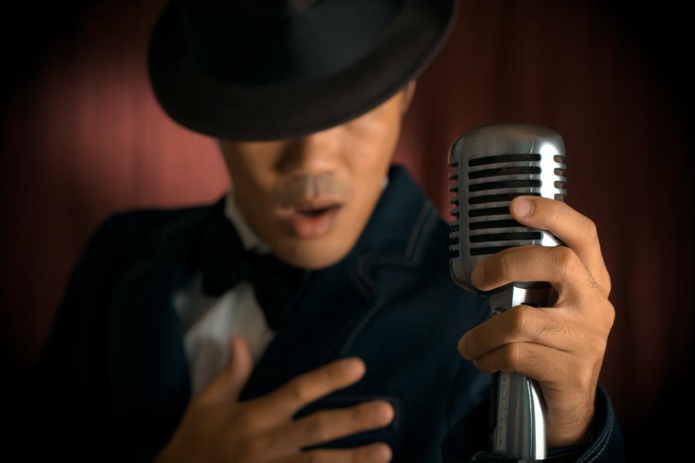 A male singer using a vintage microphone