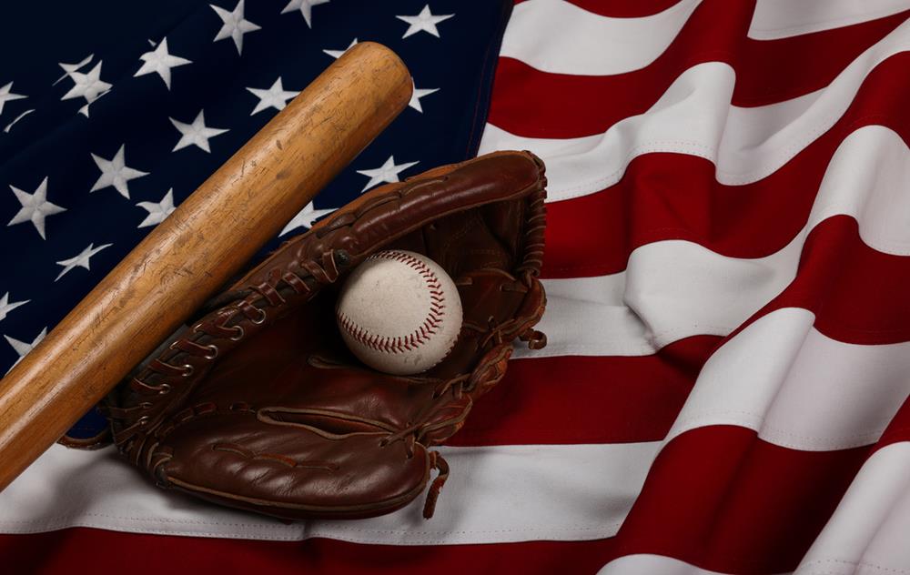 Baseball ball, bat and glove on American flag