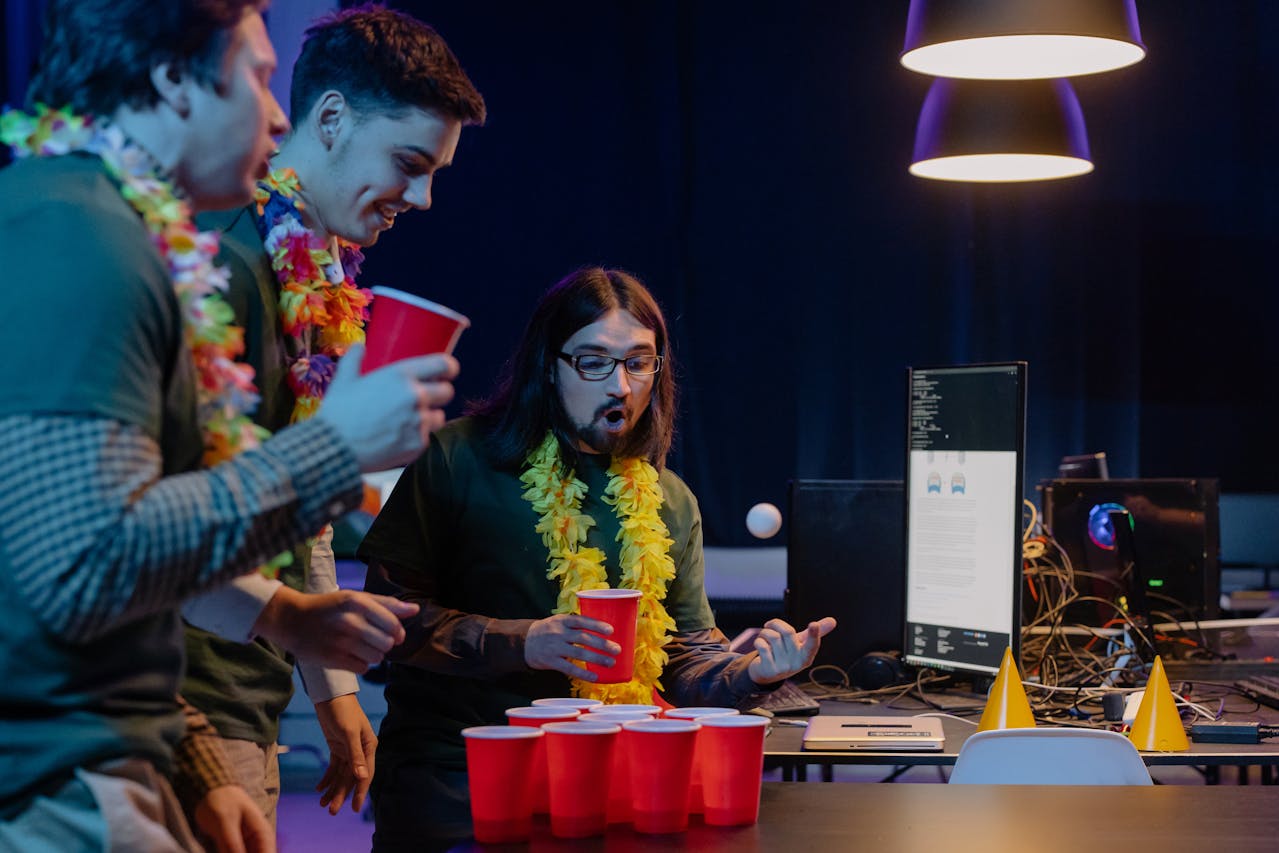 a group of guys playing beer pong