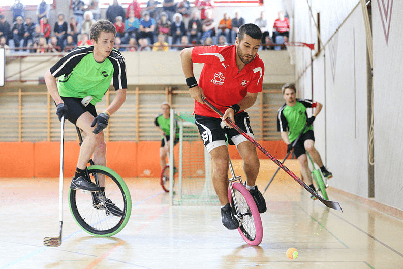 a men playing unicycle hockey