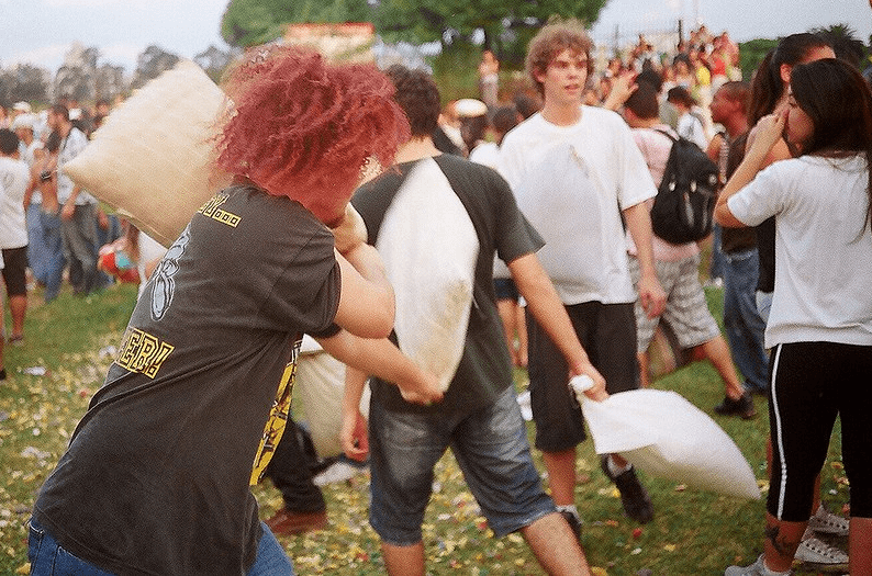 people pillow fighting outdoors