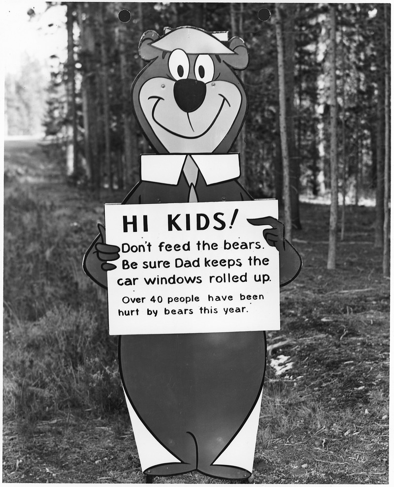 a sign with Yogi Bear that advises kids to not feed the bears in the National Park
