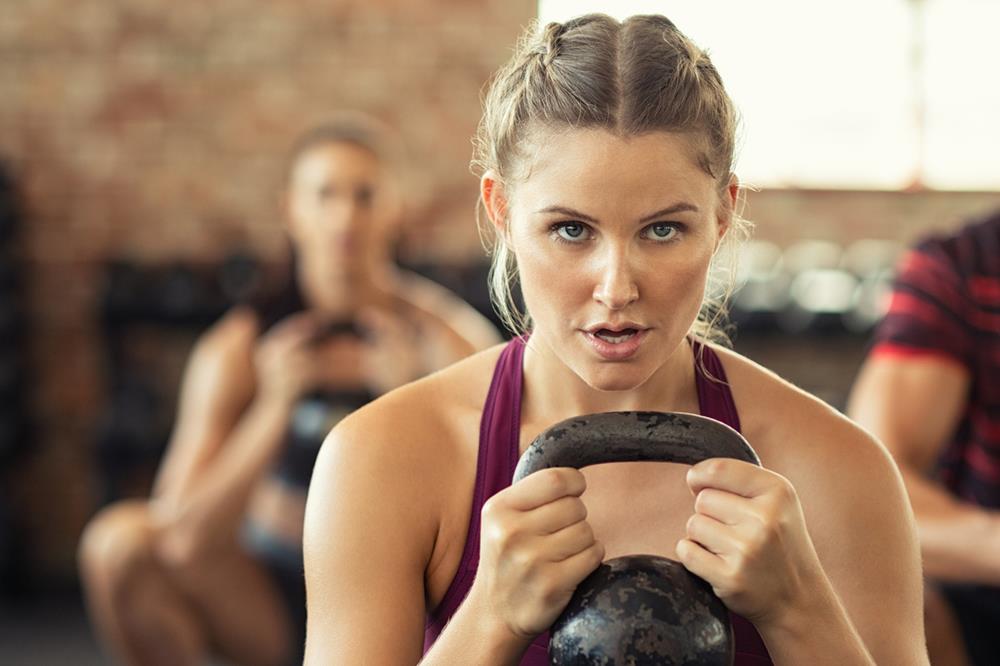 Woman working out with kettlebell at cross training gym