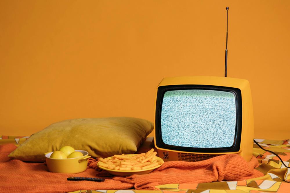 Retro TV on a bed with snacks
