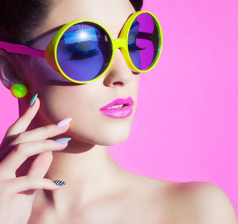 Woman wearing neon-colored accessories, makeup, and nails