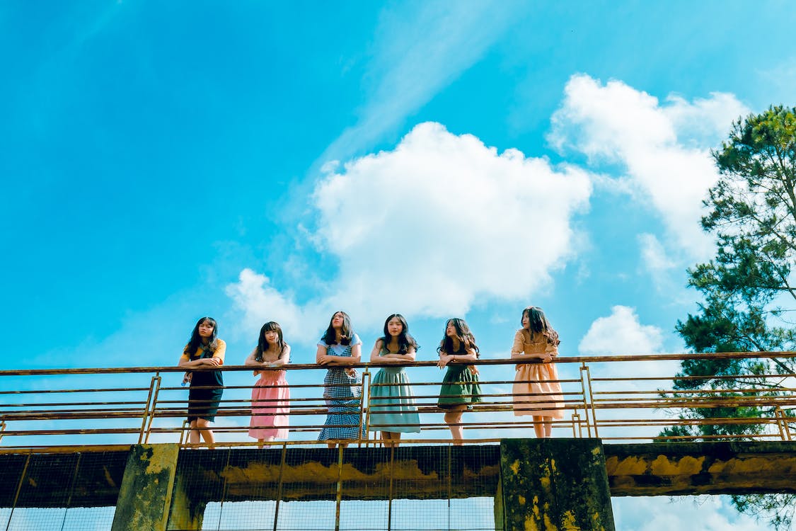 Six Women Wearing Dress Leaning on Bridge Rail