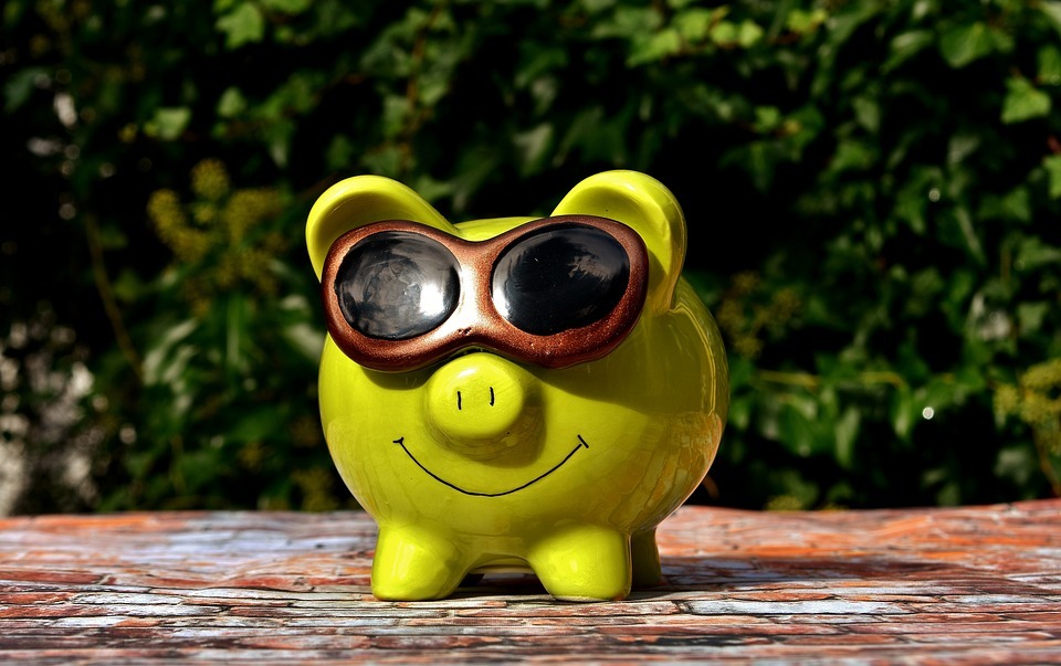 A yellow piggy bank with sunglasses