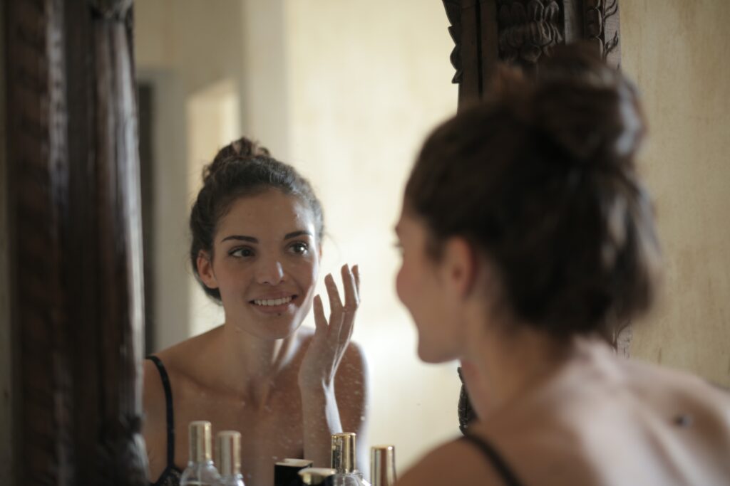 A woman applying her skincare in front of a mirror image