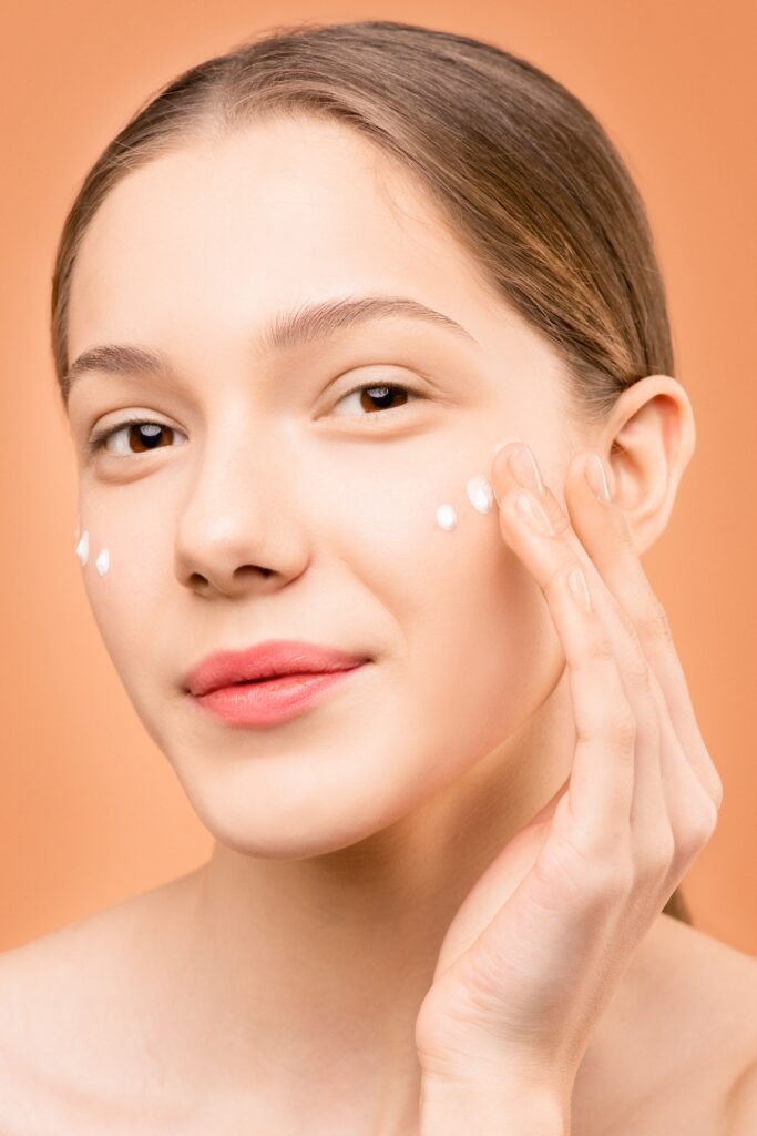 A woman applying moisturizer image
