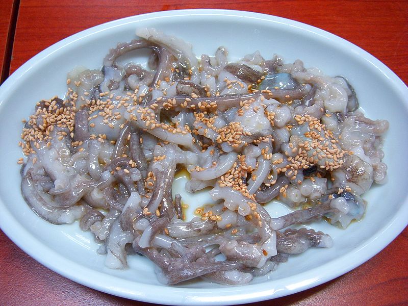 Sannakji served on a plate topped with sesame seeds