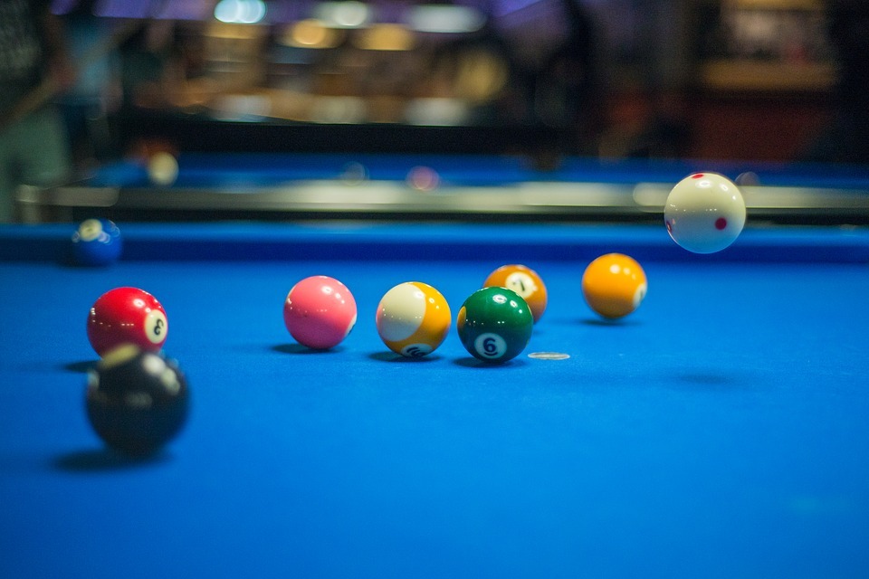Different colored snooker balls spread on a snooker table