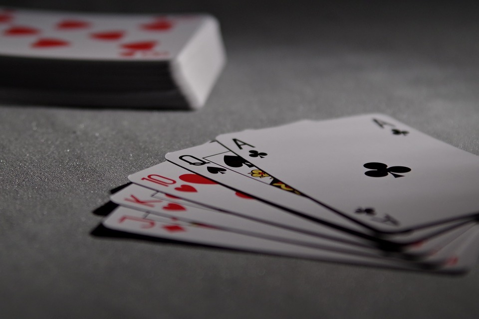 Five cards kept on a table with a deck of card stacked in the background
