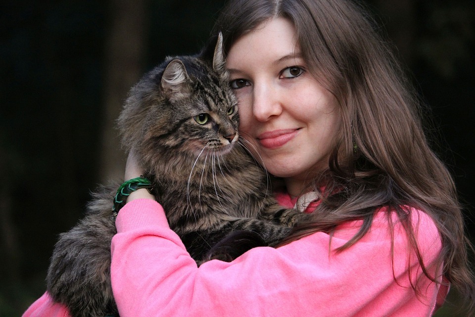 a young girl hugging a cat