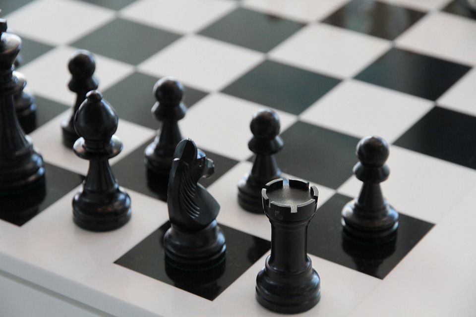 black chess pieces kept on one side of the chessboard