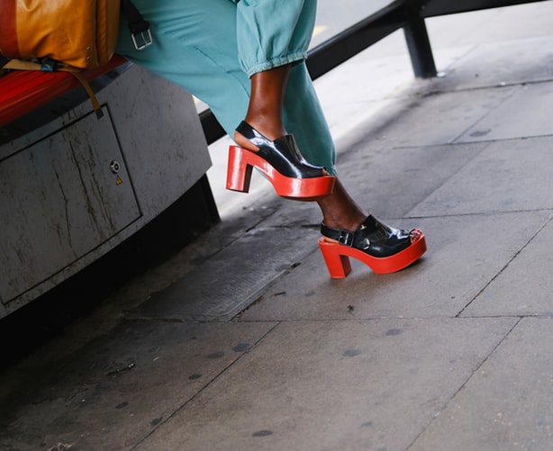 woman wearing black and red block heeled platforms with blue pants