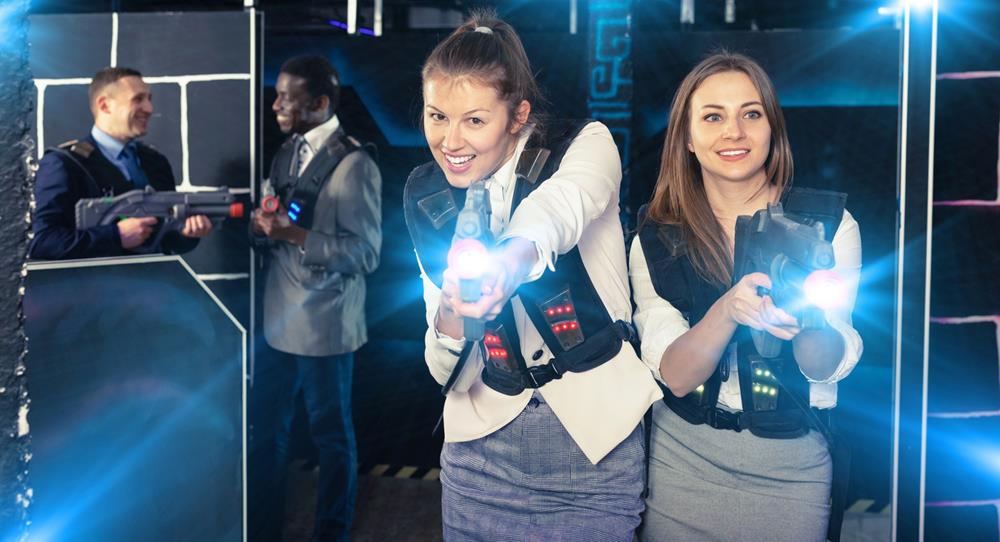 People happily playing laser tag