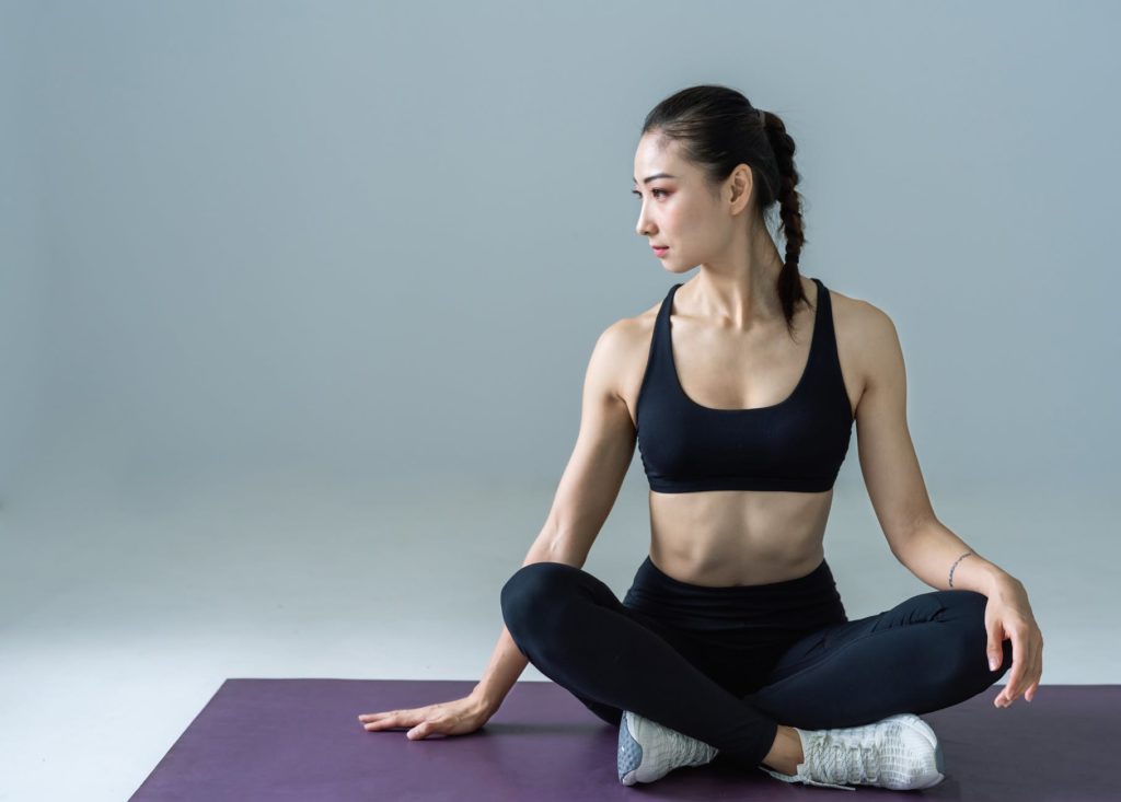 woman sitting on a workout mat