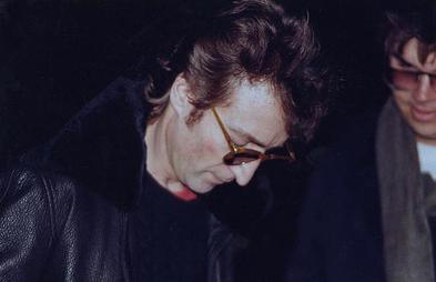 Lennon autographing a copy of Double Fantasy for Chapman, six hours before his death