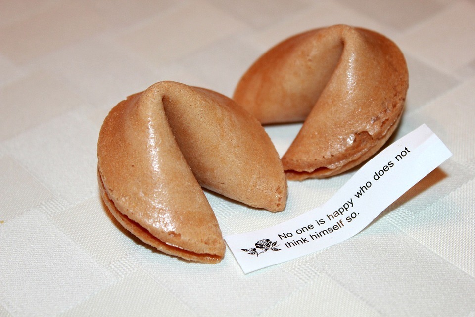 two fortune cookies with a paper containing a message