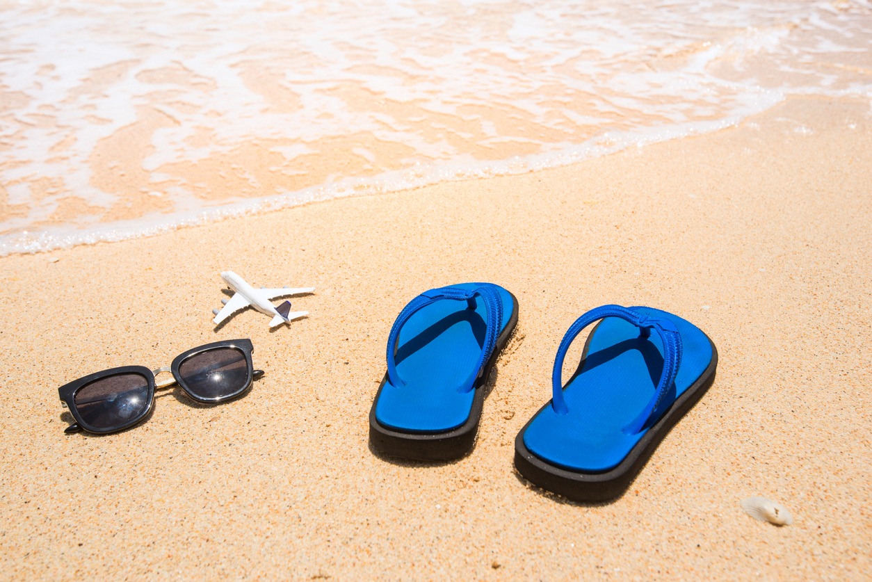 Beach, sandals, sunglasses, and airplane. Holidays travel concept