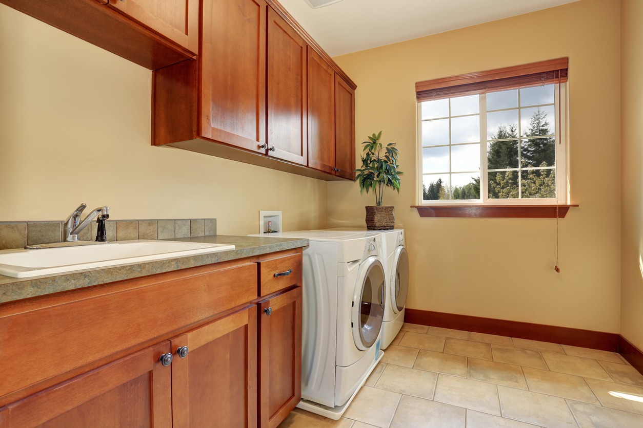 Typical laundry room with nice countertops and a tile floor