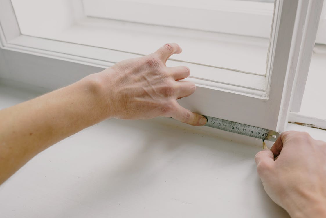 crop worker measuring window frame with a ruler