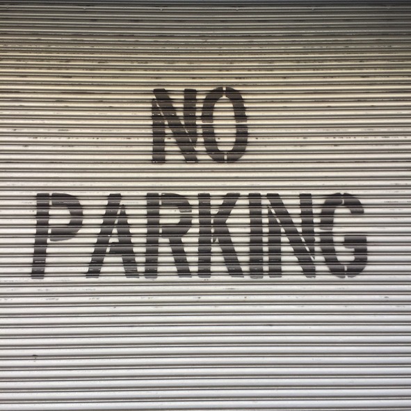 spray painted NO PARKING letters on the roller door