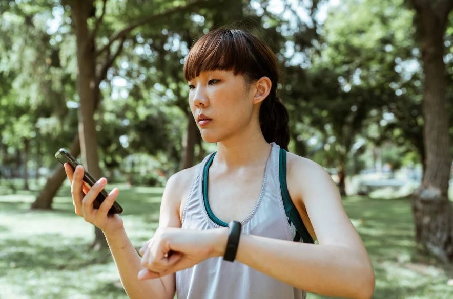 Concentrated young Asian woman using a smartphone in the park