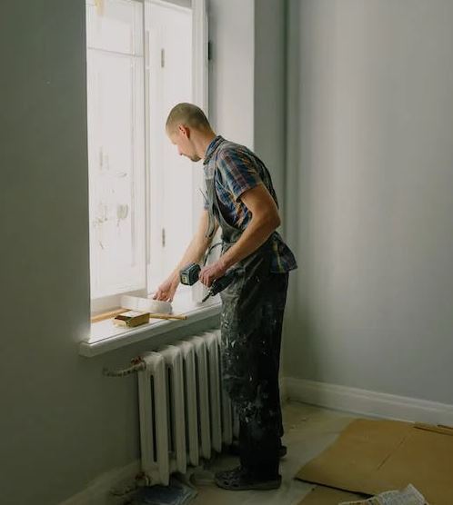 Man with screwdriver preparing for renovation in apartment
