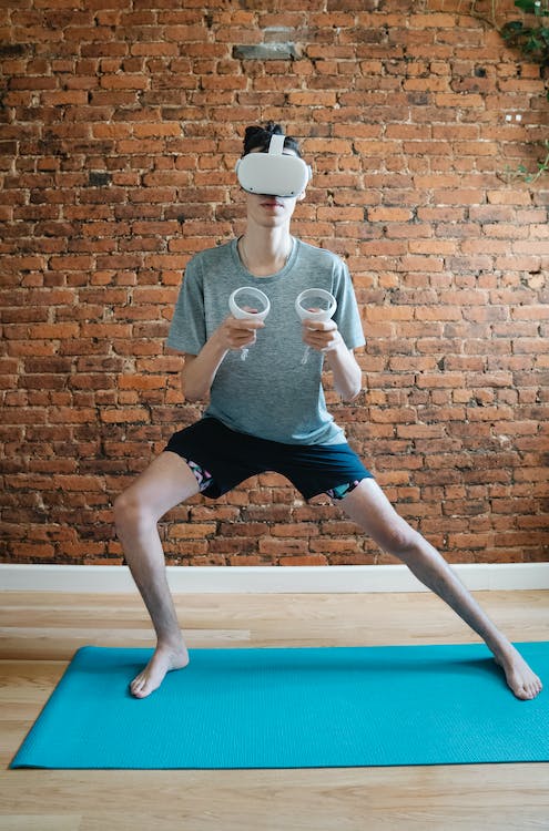 Unrecognizable man practicing yoga in a VR headset