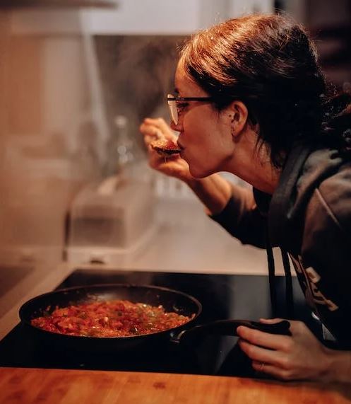 Woman Eating on Cooking Pan