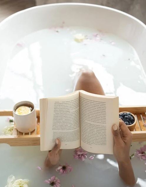 Woman reading a book in a bathtub during spa procedures