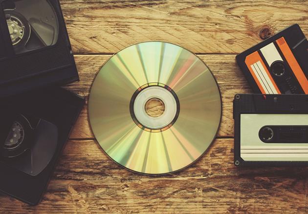 A compact disc in the middle of video tapes and cassette tapes