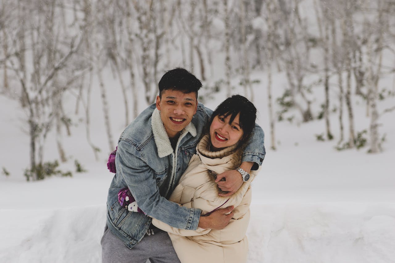 man and woman embracing each other in winter outdoors