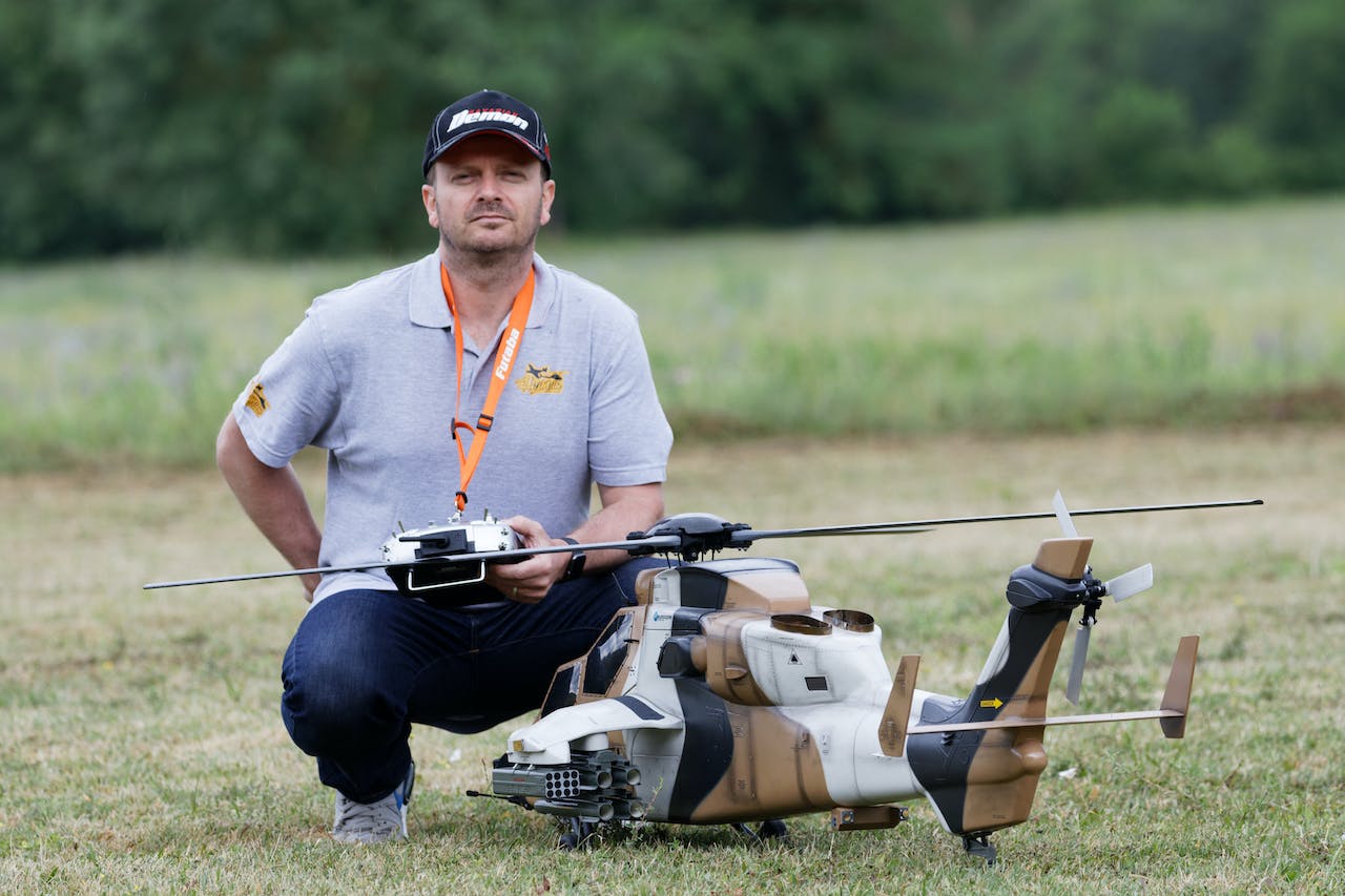 man posing near remote control helicopter toy