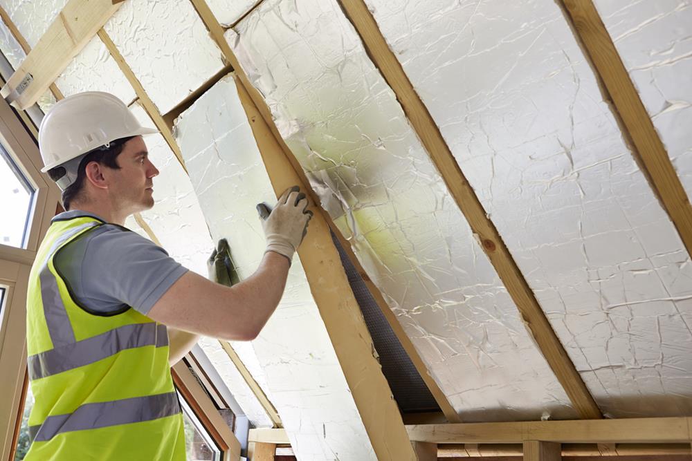 Builder fitting insulation into the roof