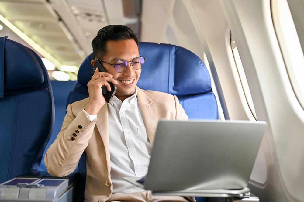 Businessman using his laptop in an airplane