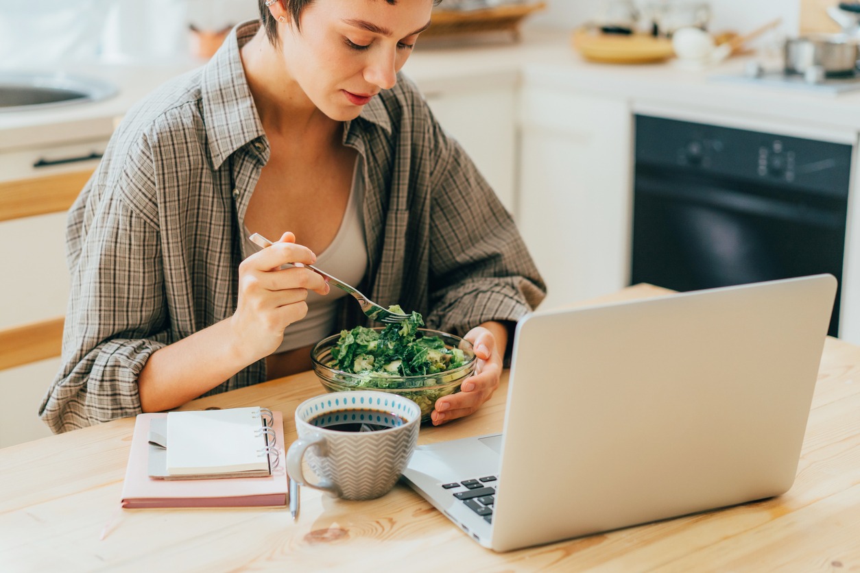 Woman eating salad while working