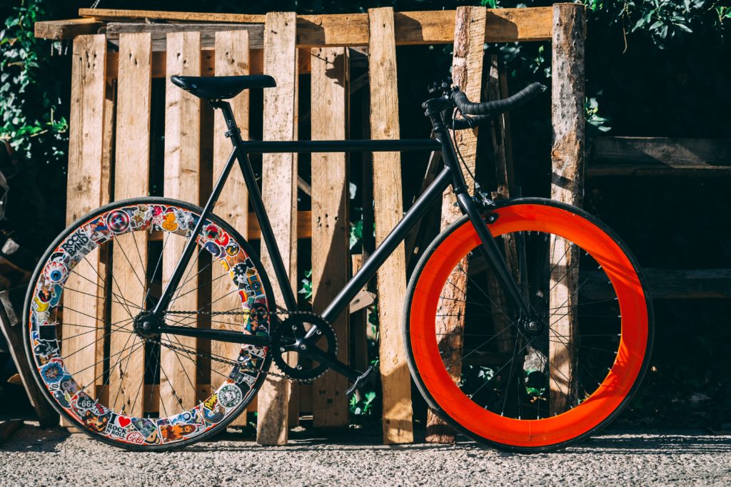 A bicycle with a black frame and multicolored wheels