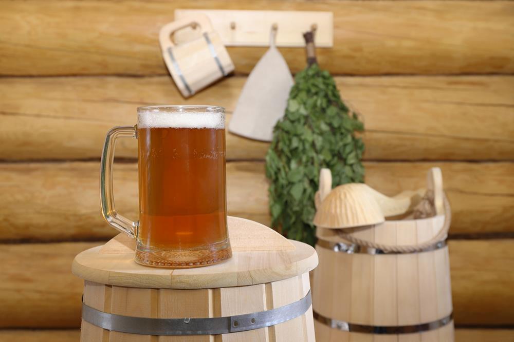 A glass of beer on an upside-down wooden barrel