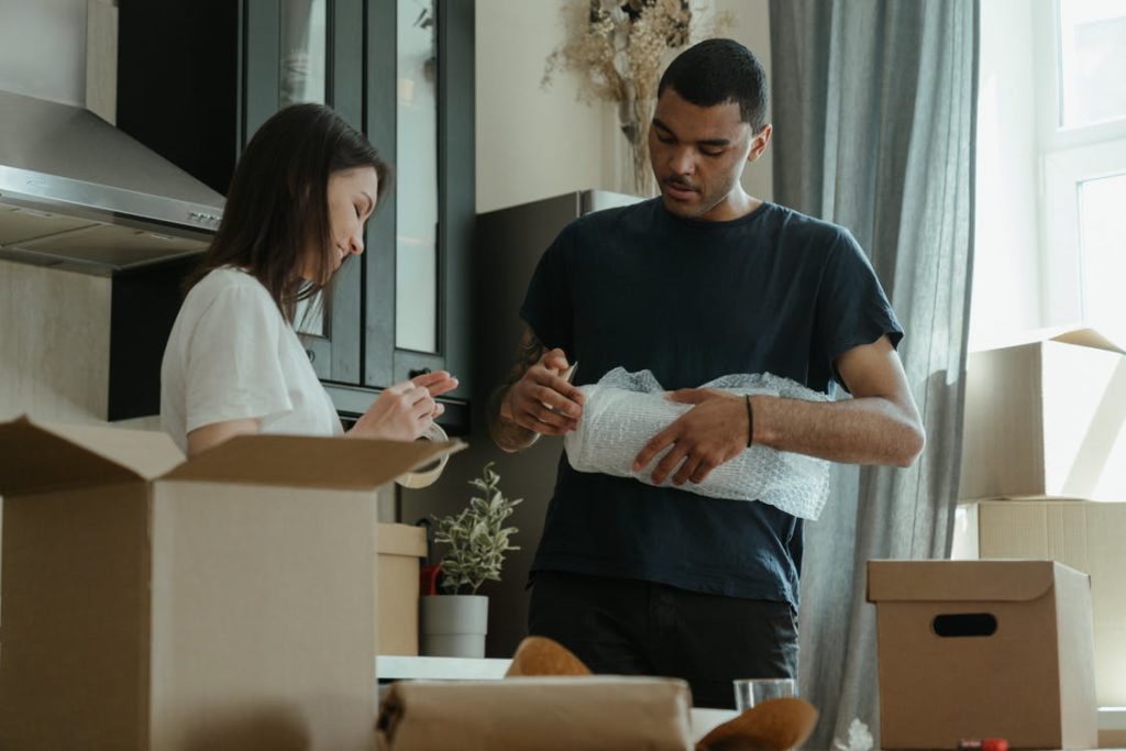 man and woman putting items in boxes