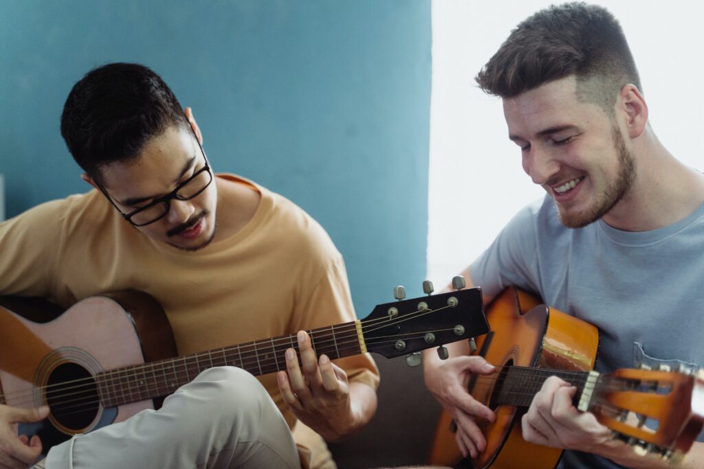 Two men playing guitars image
