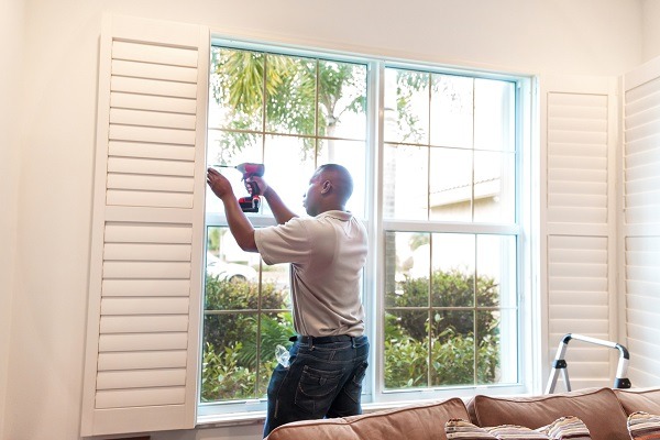 Window treatment installer installs wooden shutters RM