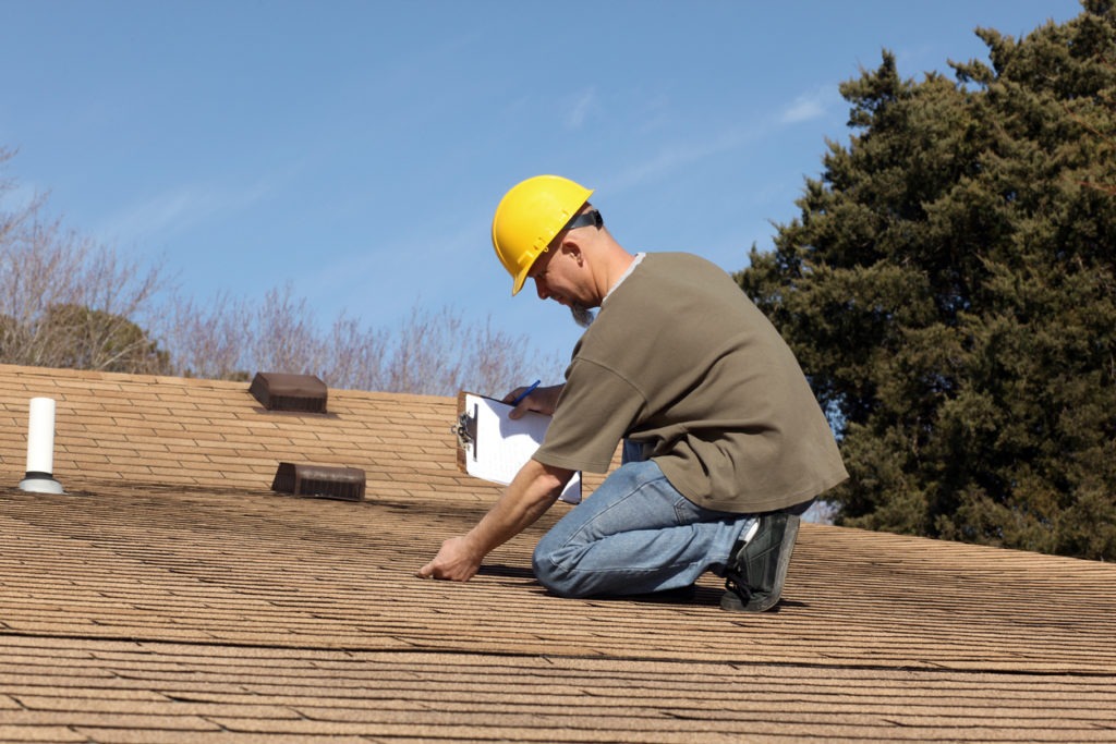Home inspector checking the roof of a house.