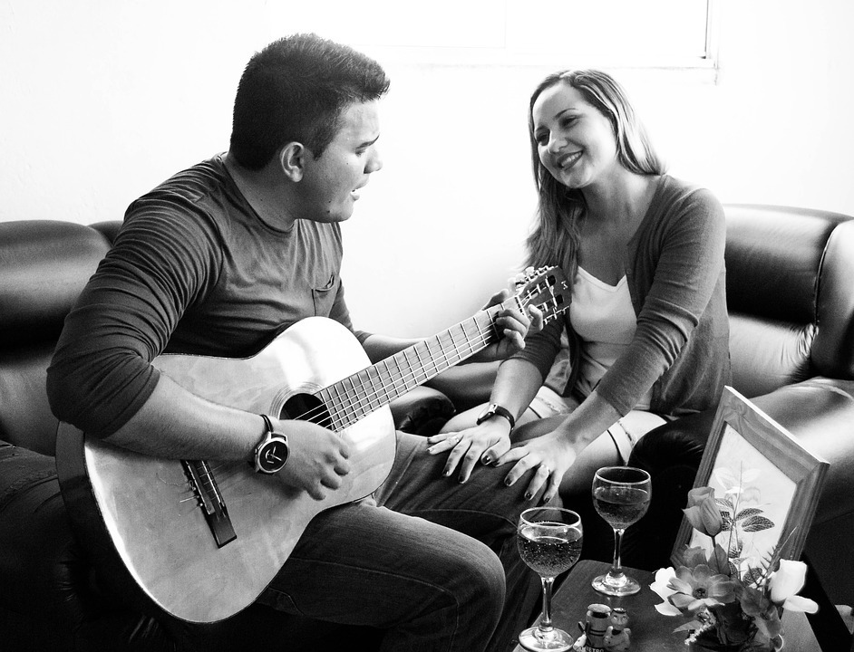 man singing to his partner while playing the guitar