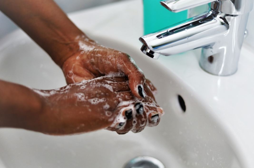 a woman cleaning her hands on the sink