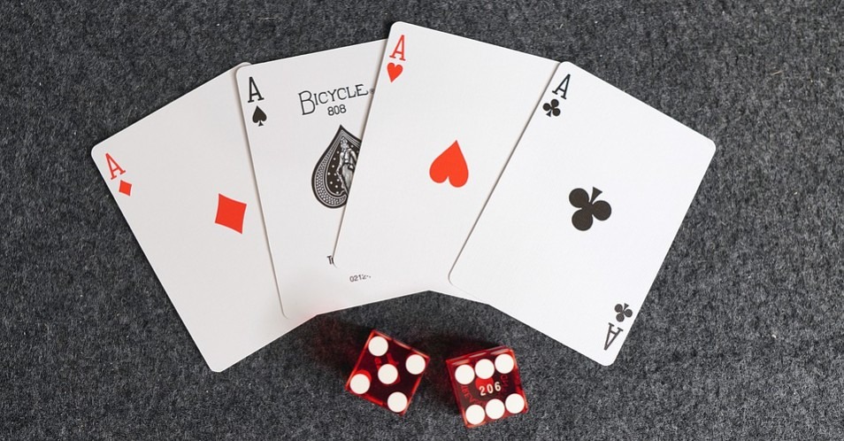 several playing cards and two red dice