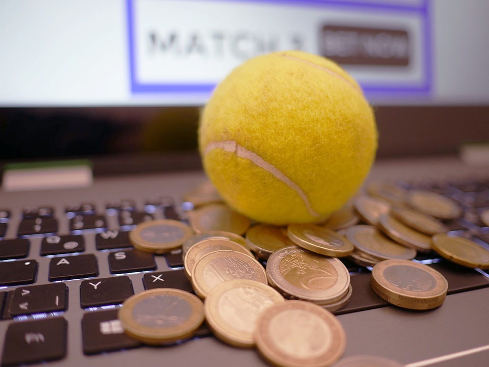 tennis ball and some coins on a laptop