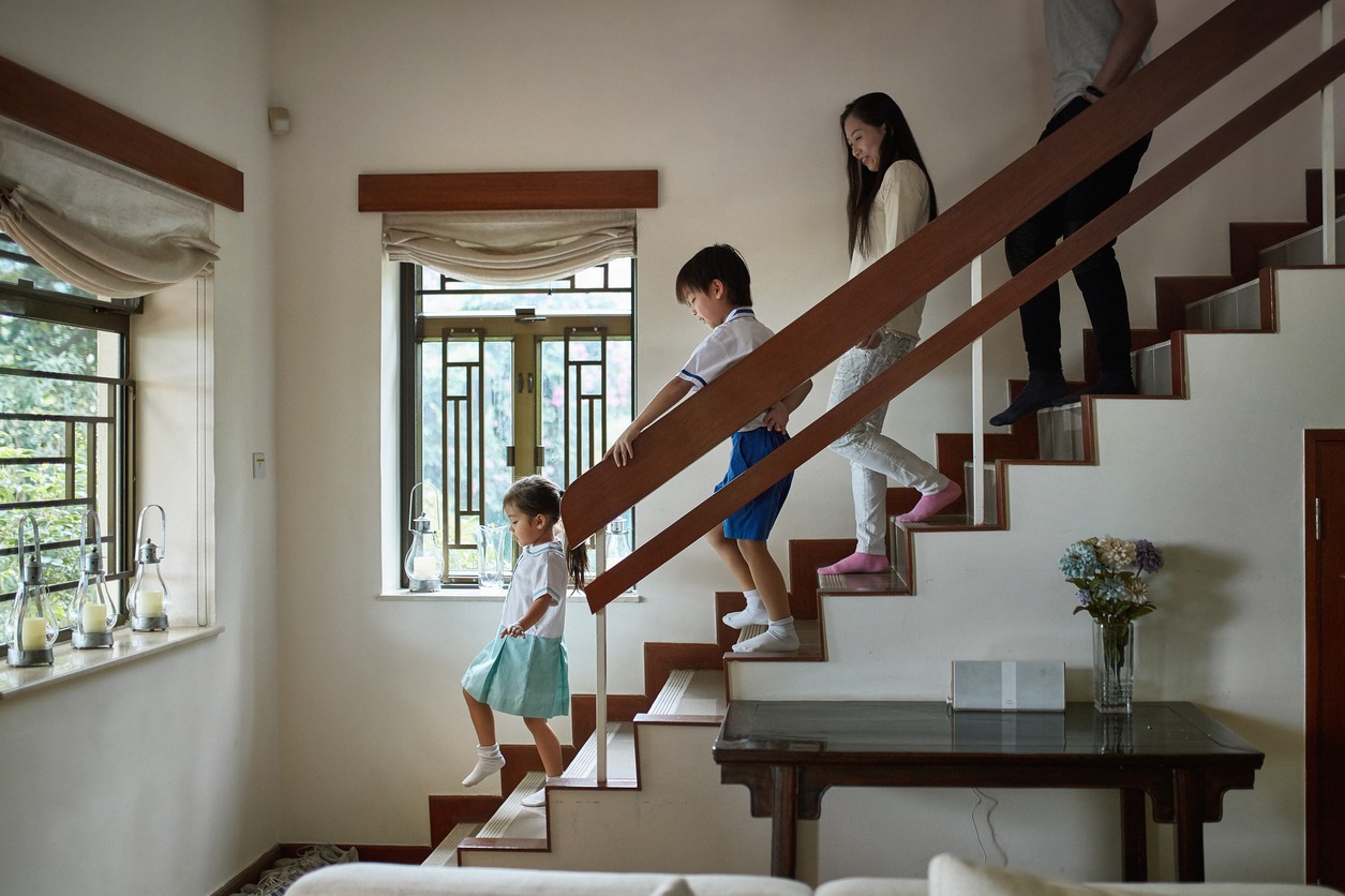 Side view of family walking down steps at home